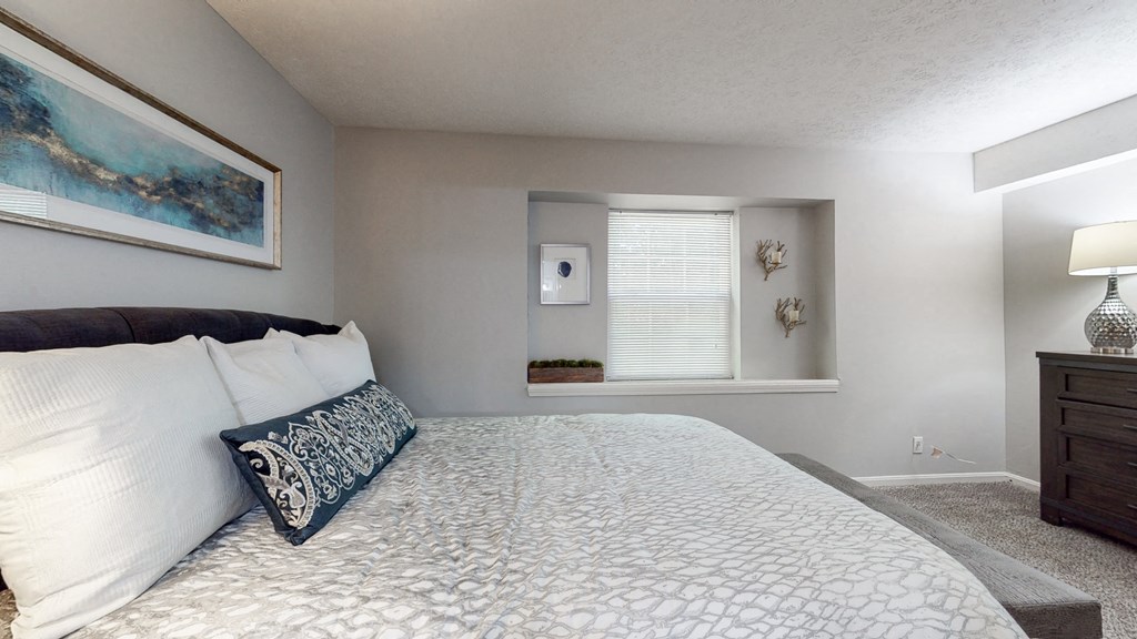 a bedroom with a large bed and a window