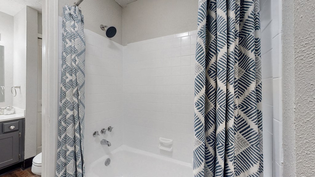 a bathroom with a shower and a toilet and a shower curtain