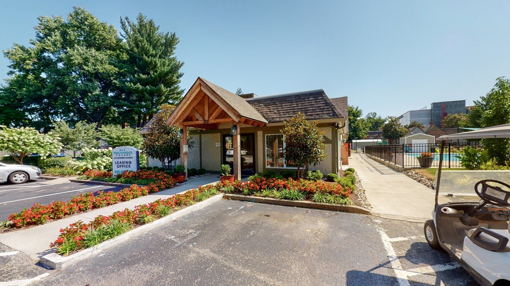 the front of a small house with a driveway and a parking lot