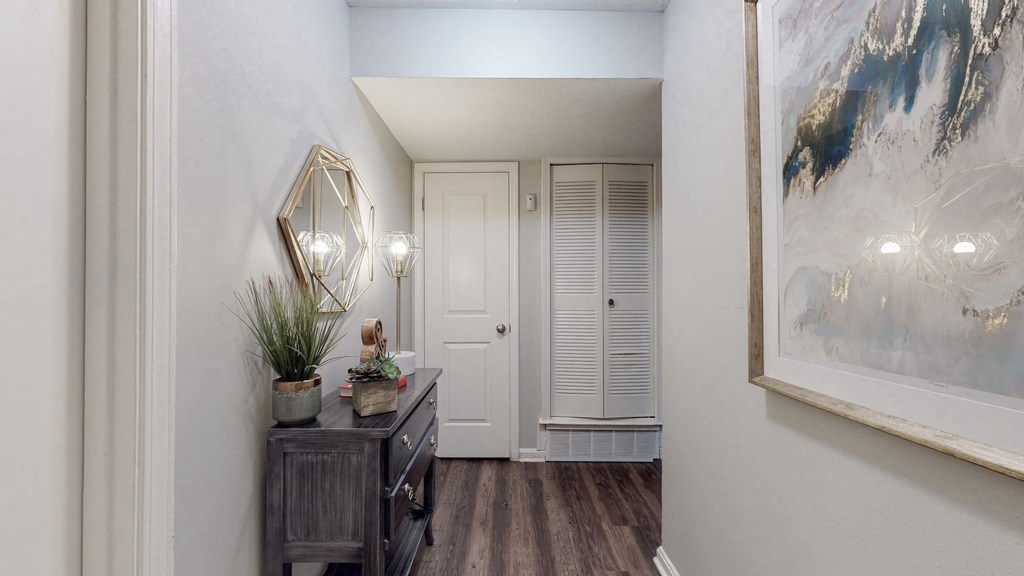 a hallway with a white door and a door to a closet