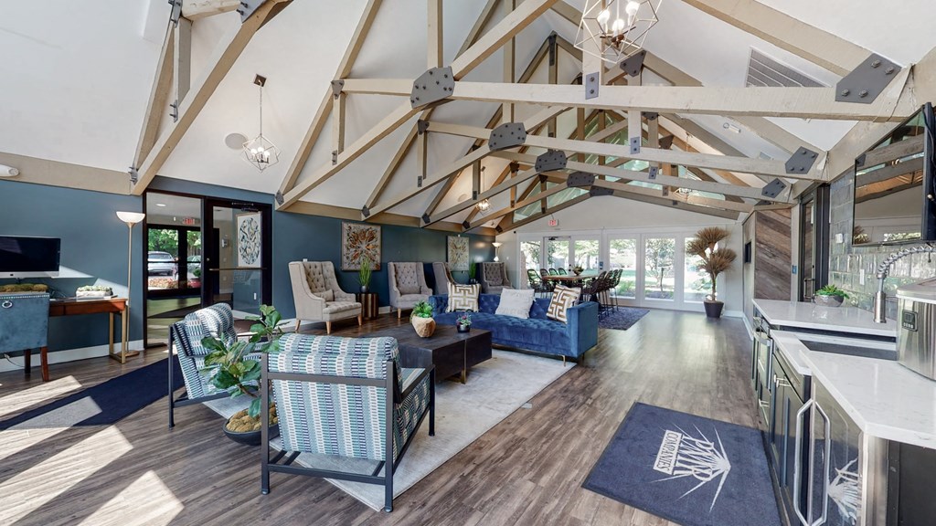a large living room with blue couches and a kitchen