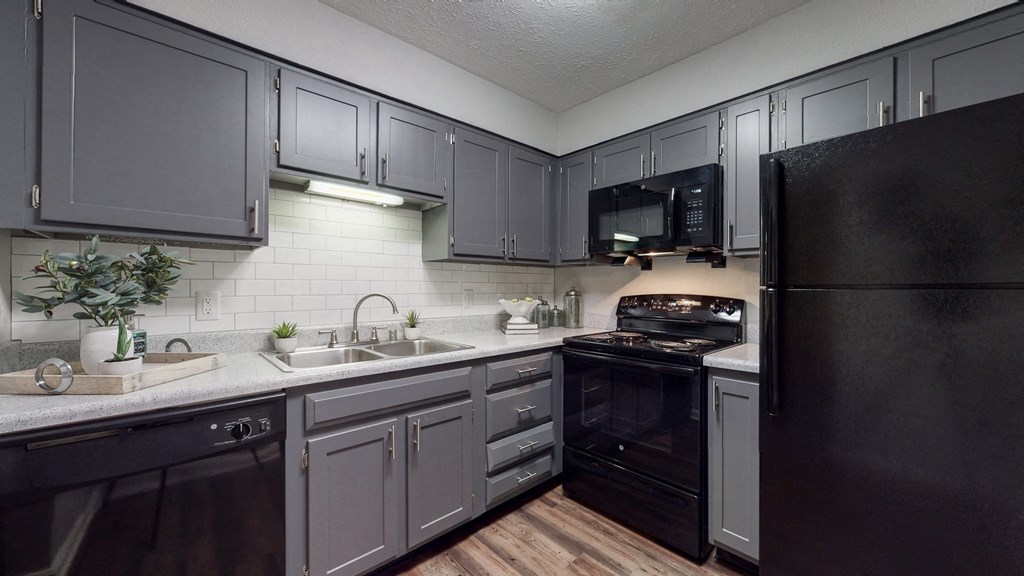 a kitchen with black appliances and gray cabinets