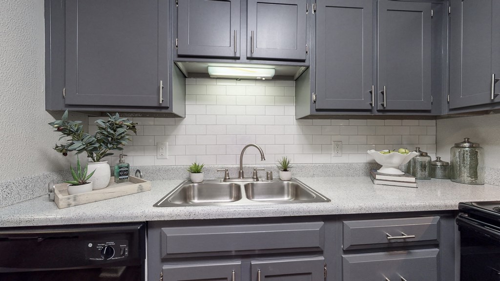 a kitchen with gray cabinets and a sink