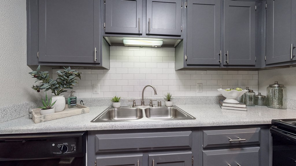 a kitchen with gray cabinets and a sink