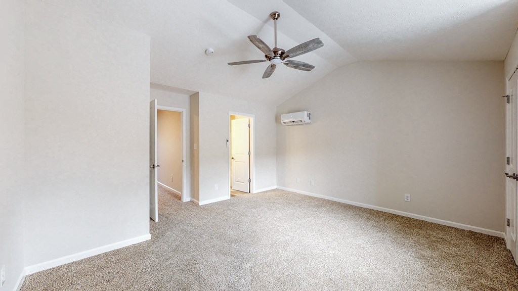 an empty living room with a ceiling fan