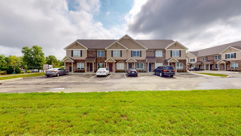 a large house with cars parked in a parking lot