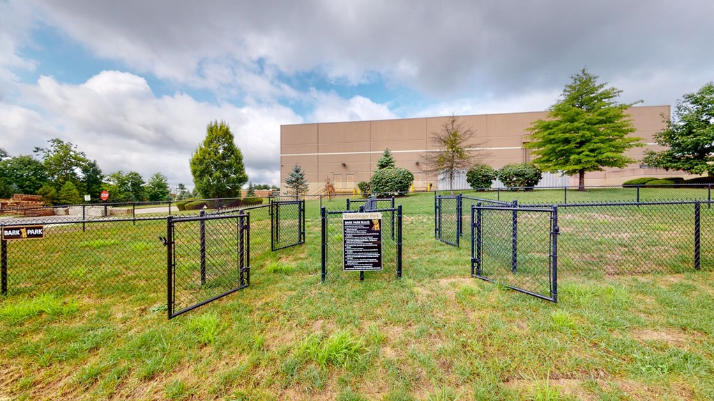 a dog park in front of a building with a dog fence