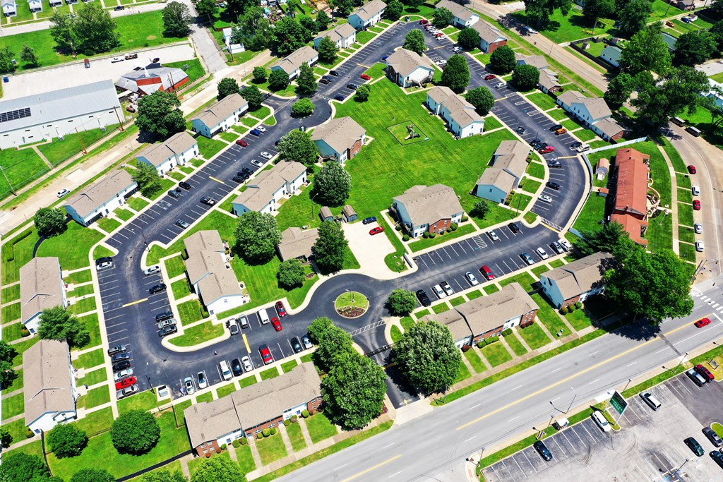 an aerial view of a neighborhood with cars parked in a parking lot