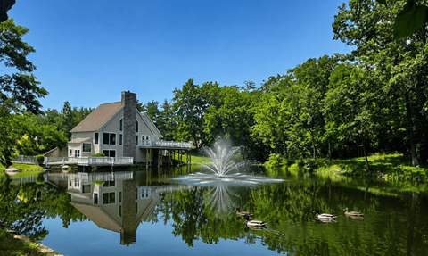 A house is reflected in the water of a pond.
