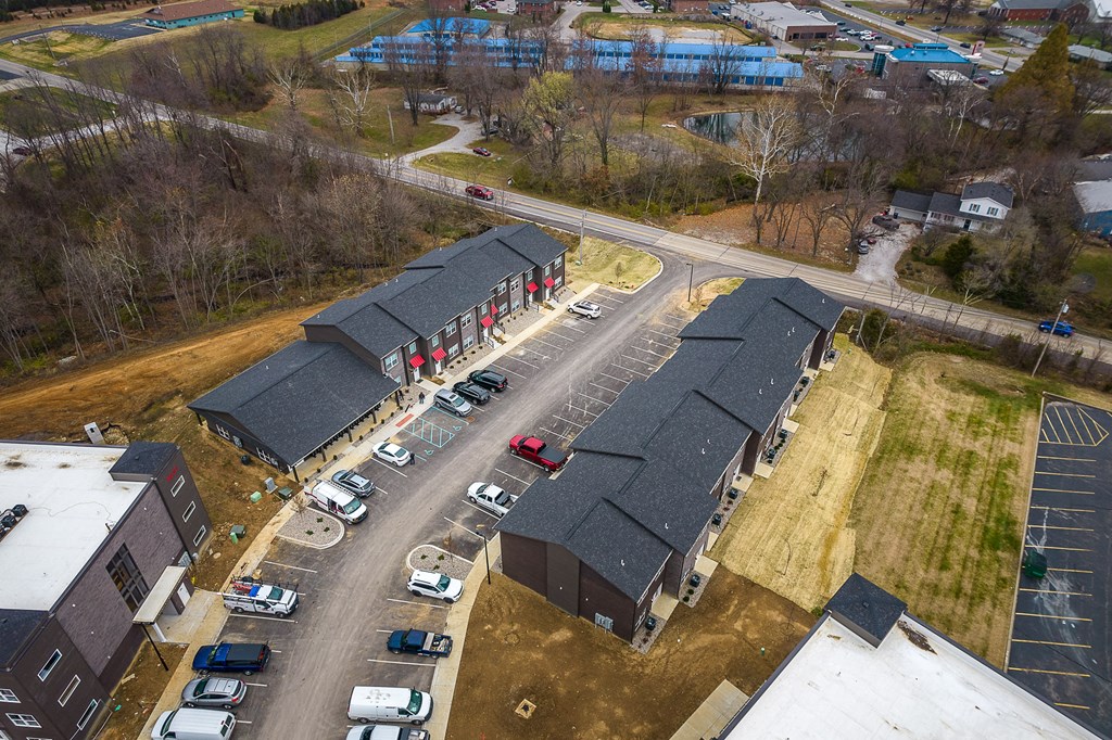An aerial view of a parking lot with cars and buildings.