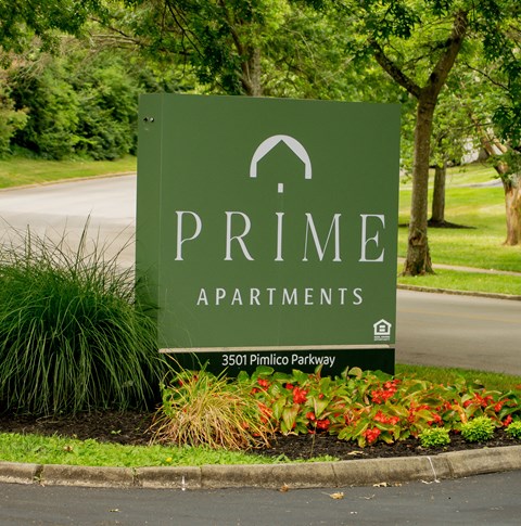 a sign for prime apartments in front of a road