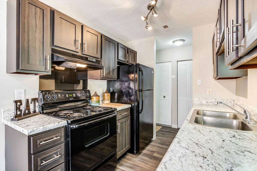 a kitchen with stainless steel appliances and marble counter tops