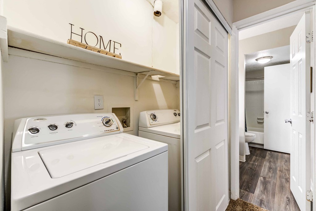 a washer and dryer in a laundry room with a door to the bathroom