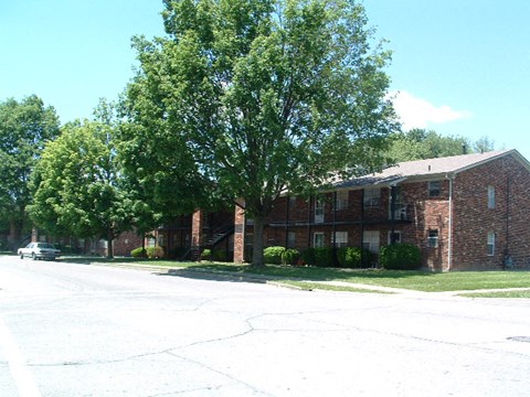a red brick building with a tree in front of it