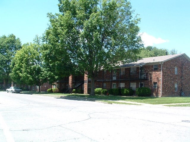 a red brick building with a tree in front of it