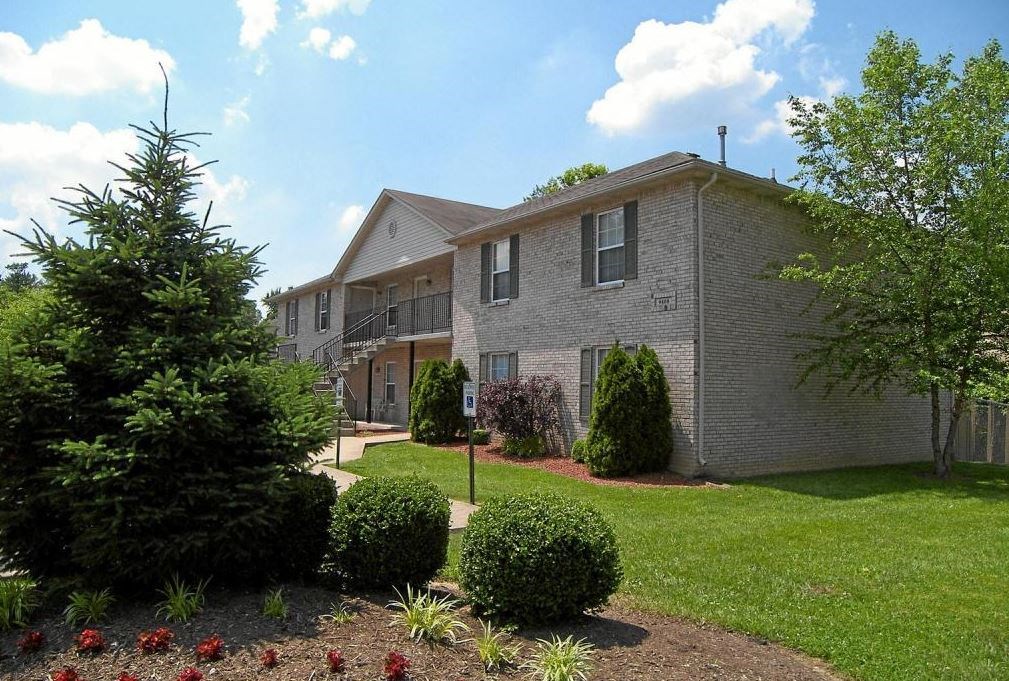 a white brick house with a yard and trees
