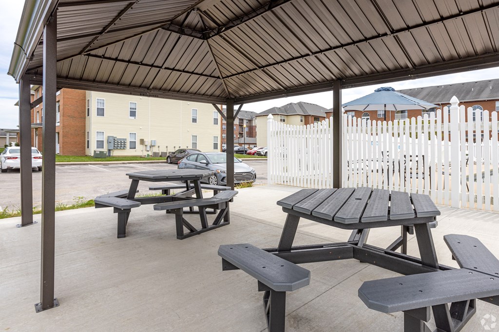 an outdoor pavilion with picnic tables in a parking lot