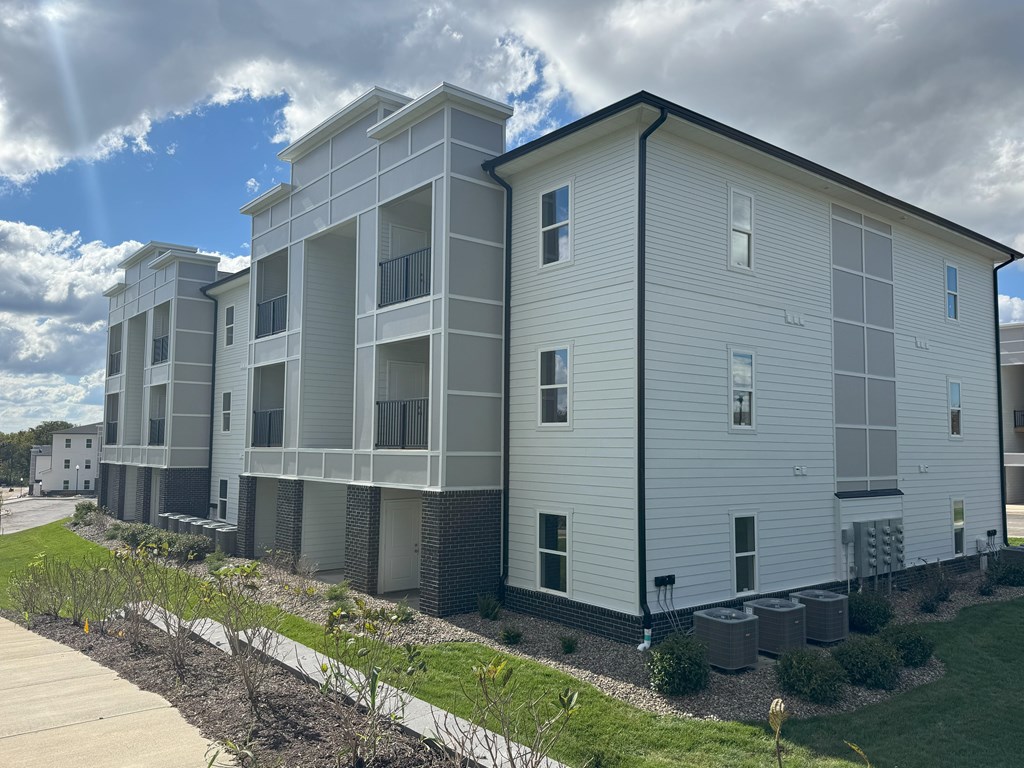 Apartment building with a walkway in front.