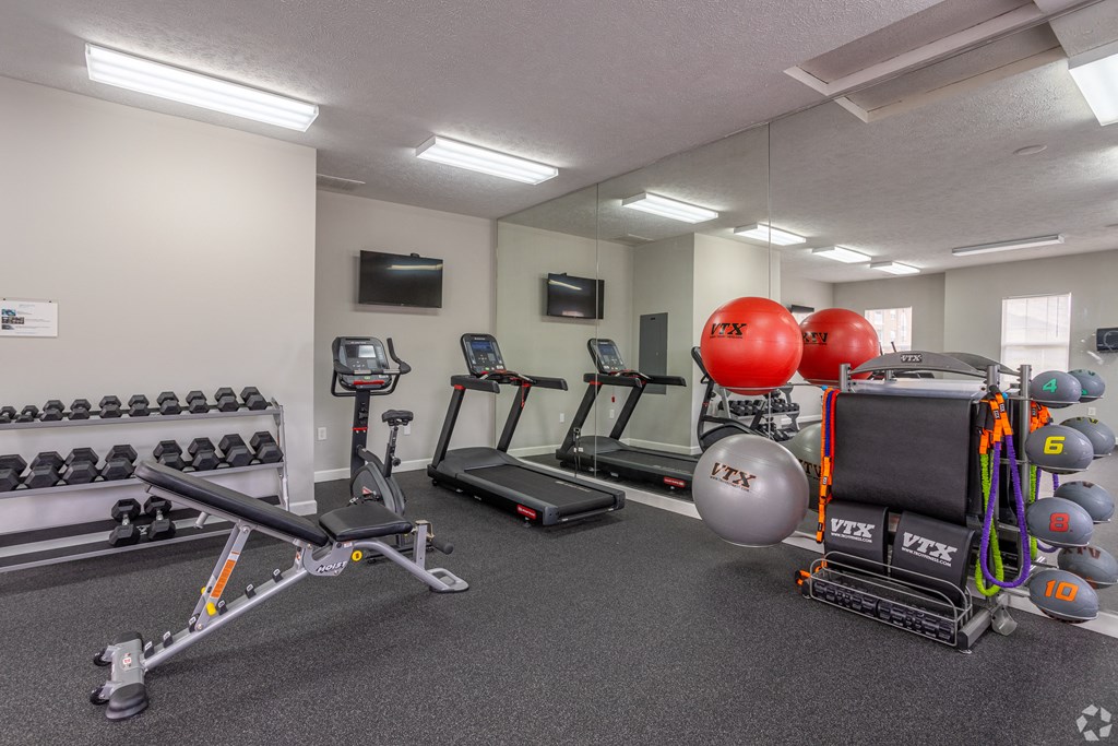 a gym with cardio equipment and weights in a building