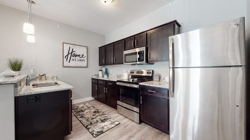 a kitchen with dark wood cabinets and stainless steel appliances