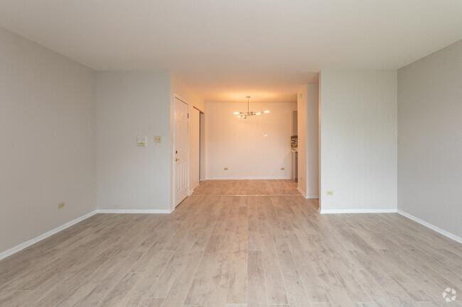 an empty living room with white walls and wood floors