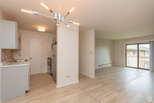 an empty room with a kitchen and a living room