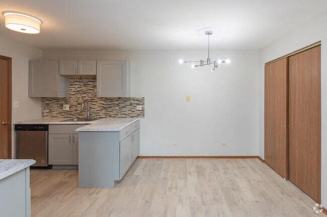 an empty kitchen with a sink and a refrigerator