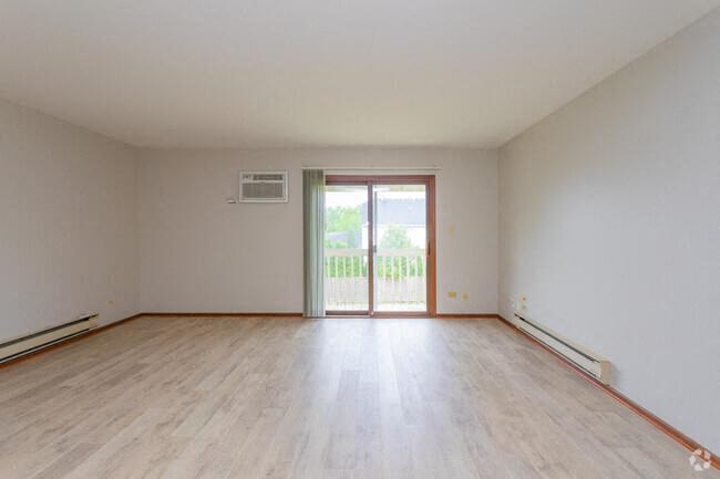 an empty living room with a wood floor and a door