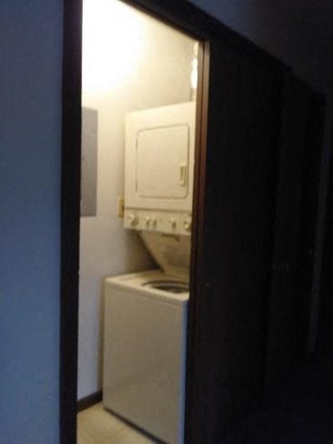 a bathroom with a white refrigerator and a washing machine