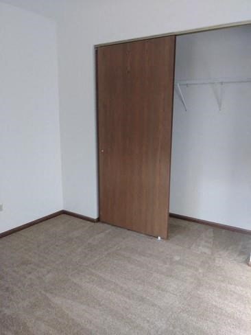 an empty room with a door to a closet