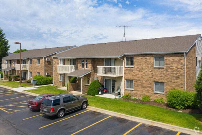 a parking lot with cars parked in front of an apartment building