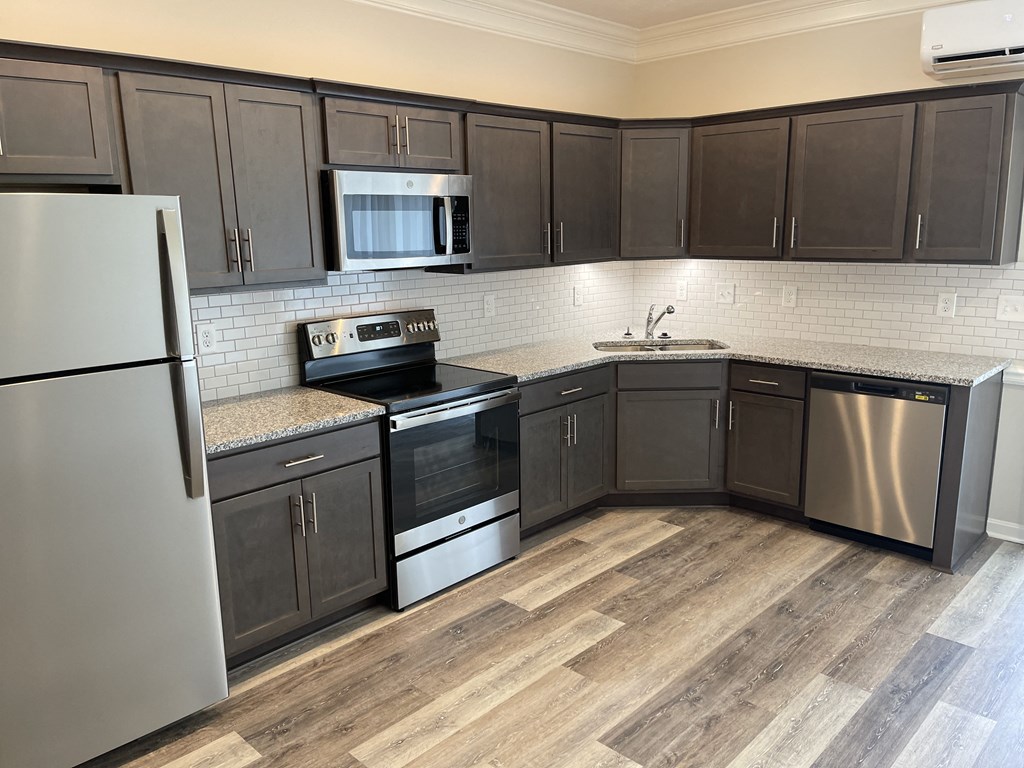 a kitchen with dark cabinets and stainless steel appliances