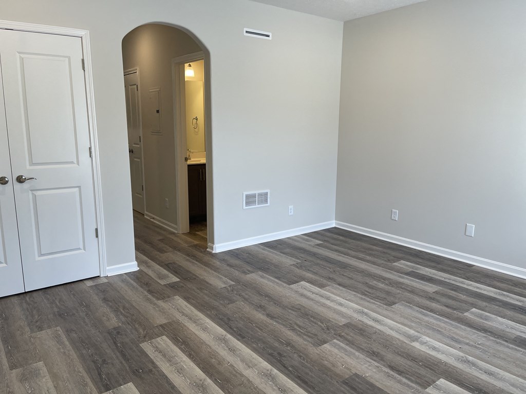 an empty living room with wood flooring and a white door