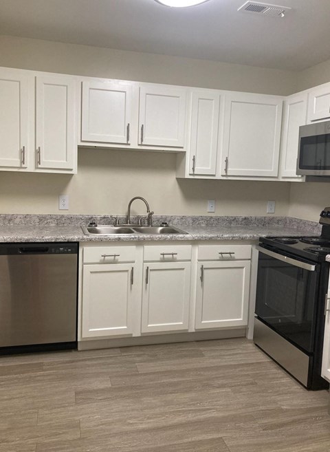 a kitchen with white cabinets and stainless steel appliances