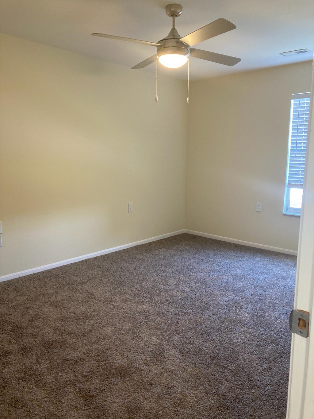 a bedroom with a ceiling fan and carpet