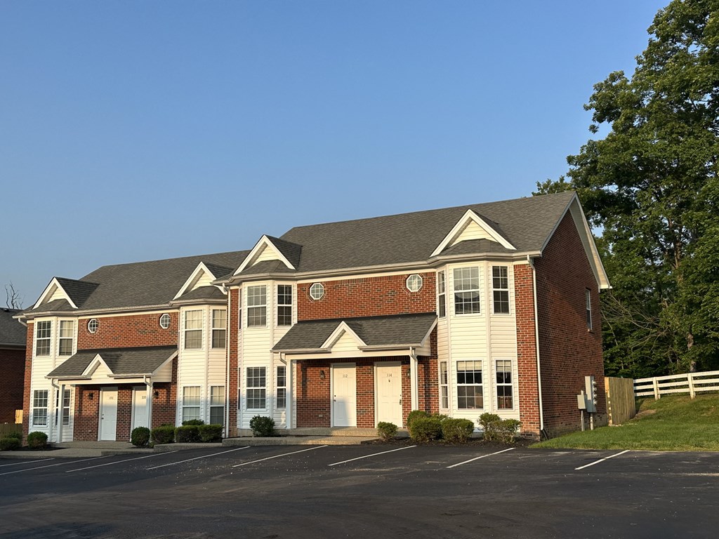 a large brick house with a tree in front of it