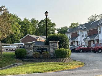 the front yard of a house with a parking lot and a street sign