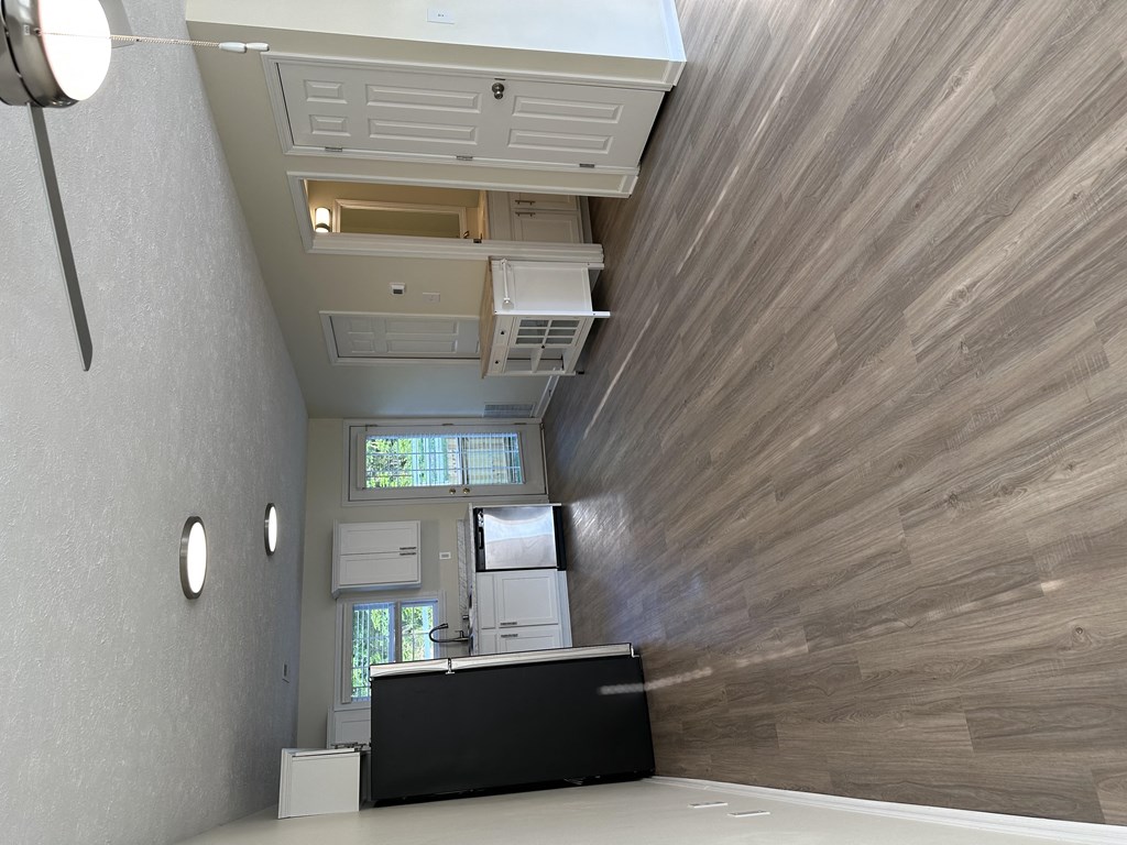 a living room with a tv and a wood wall