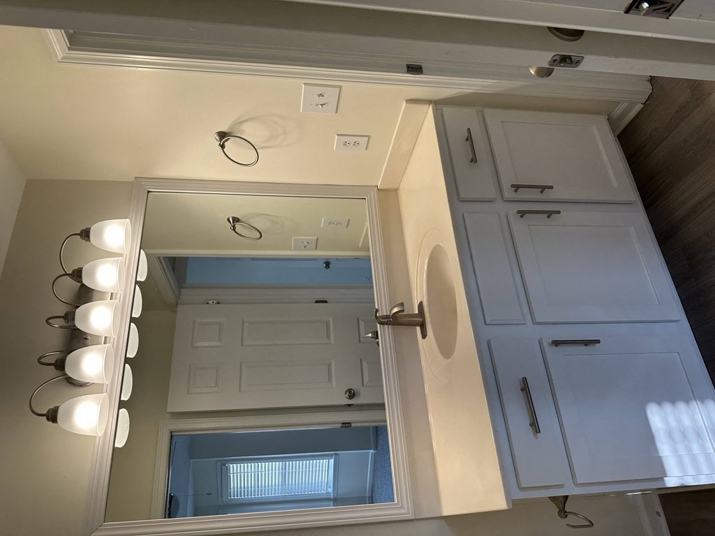 a small bathroom with a large mirror and a white door