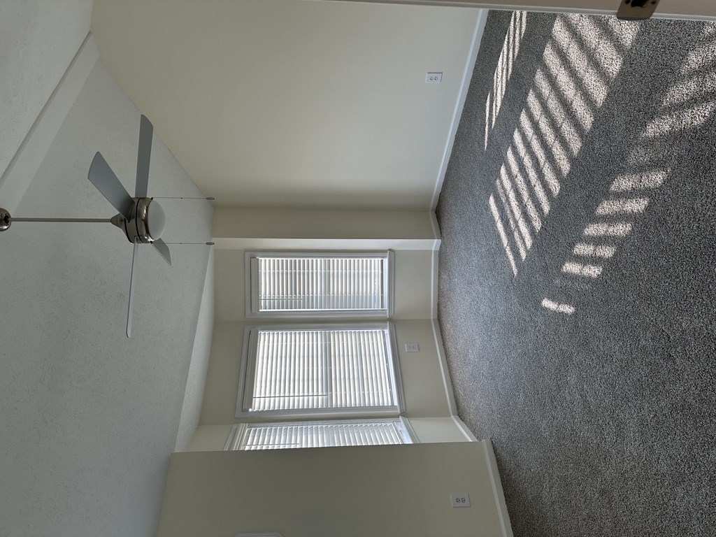 a room with a window and a ceiling fan