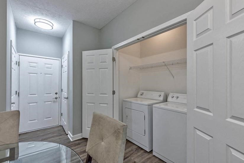 a laundry room with white appliances and a table