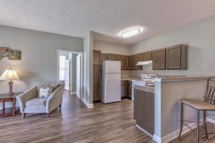 a kitchen and a living room with a refrigerator