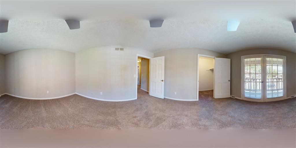 an empty living room with white walls and a door