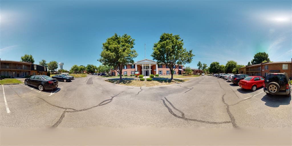 a parking lot with cars in front of a building