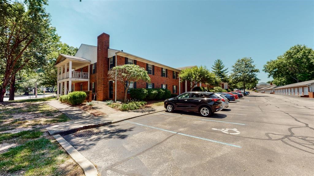 a parking lot with cars parked in front of a brick building