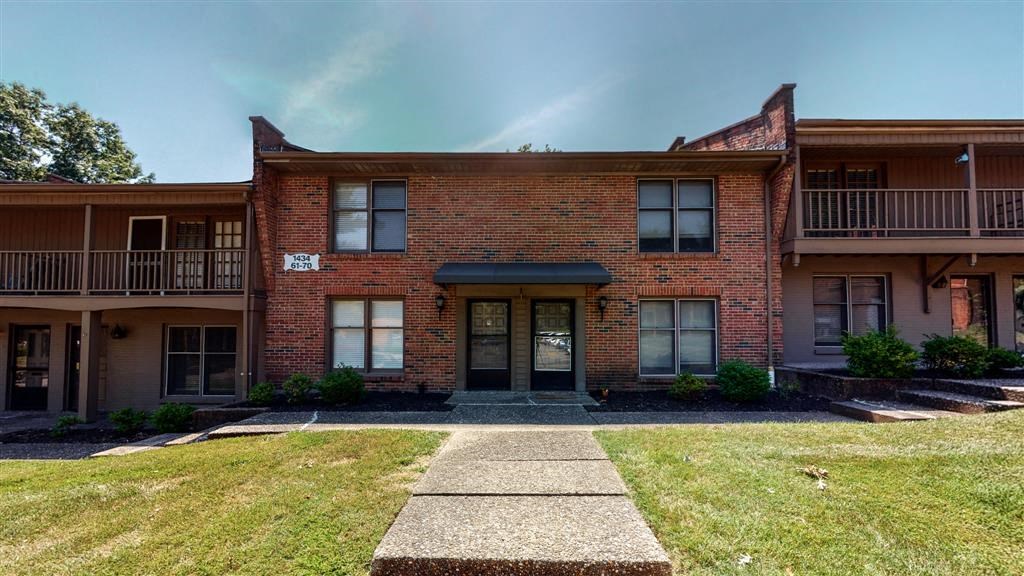 a brick building with a sidewalk in front of it