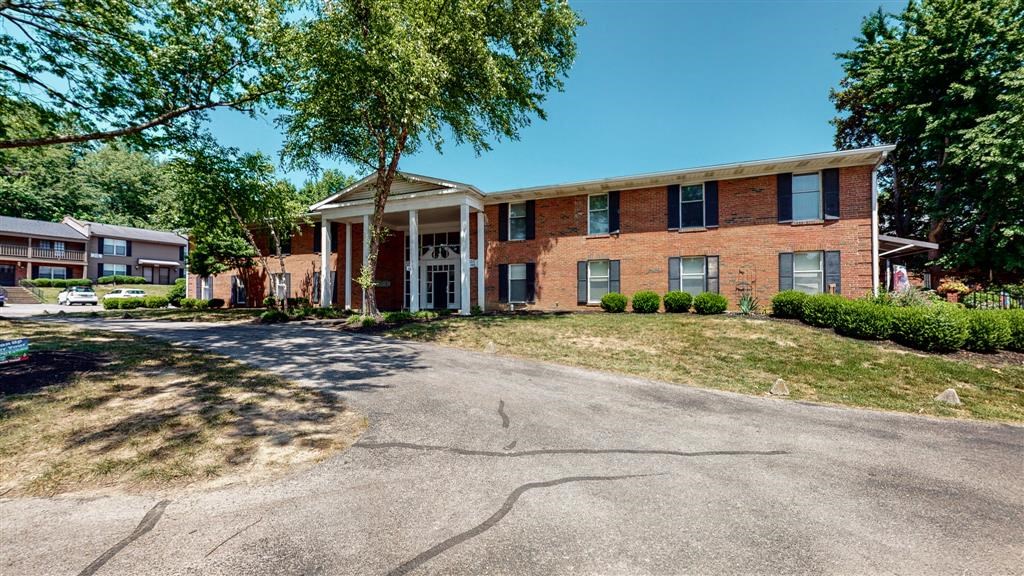 a large brick house with a tree in front of it