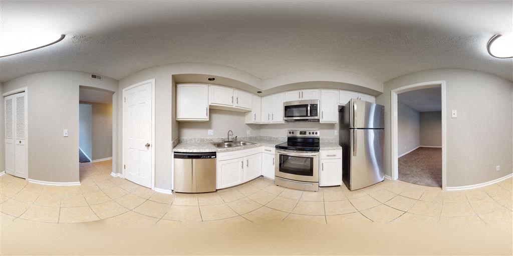 a large kitchen with white cabinets and stainless steel appliances