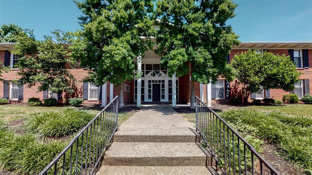a building with stairs and trees in front of it