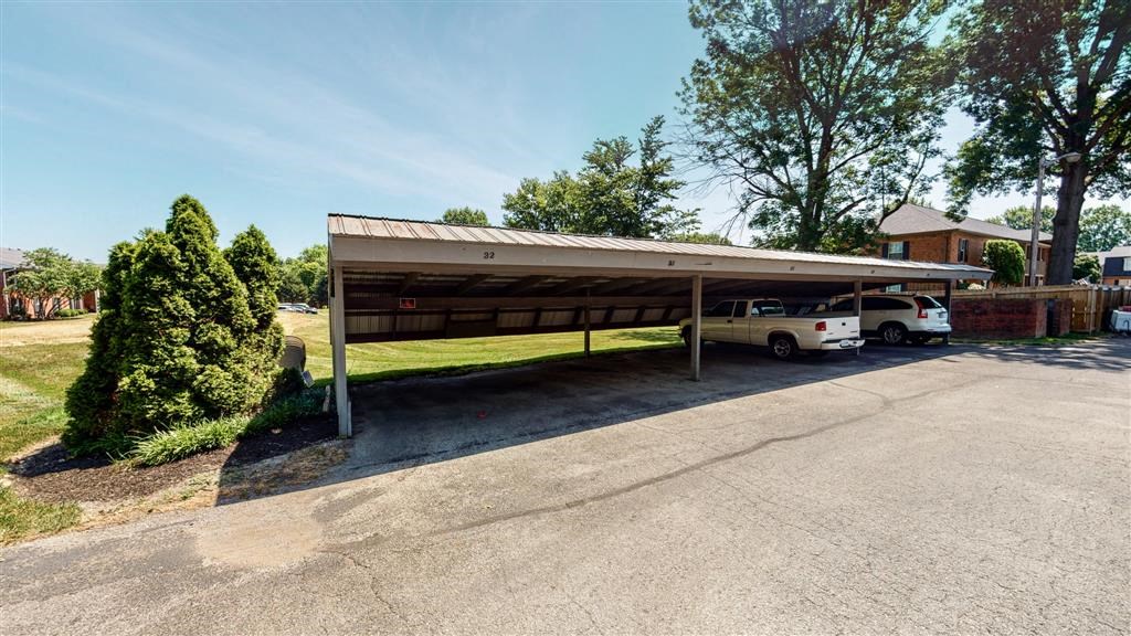 a parking lot with two cars parked under a roof